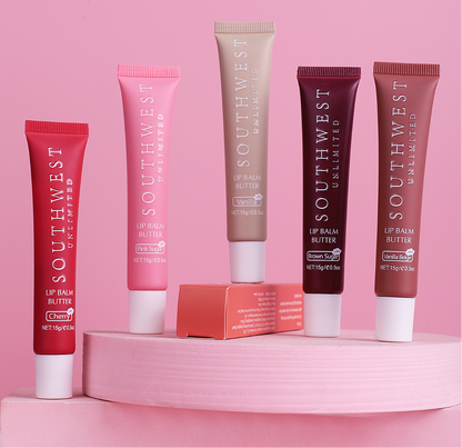 SOUTHWEST UNLIMITED lipbutters in assorted colors with a smooth, creamy texture displayed on a wooden surface.